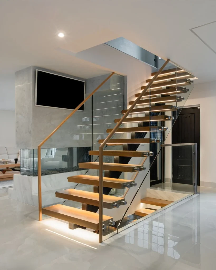 Contemporary Staircases Mix Glass with Warm Brass Accents