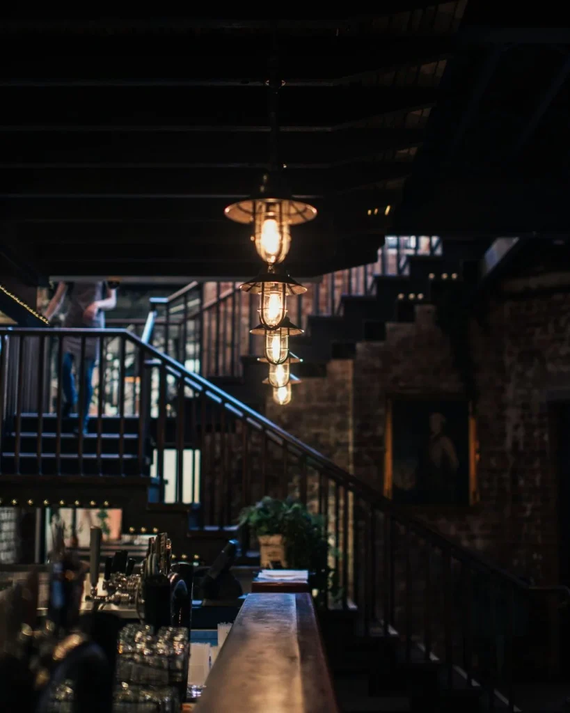 amber glass pendant lights hanging over a basement home bar counter