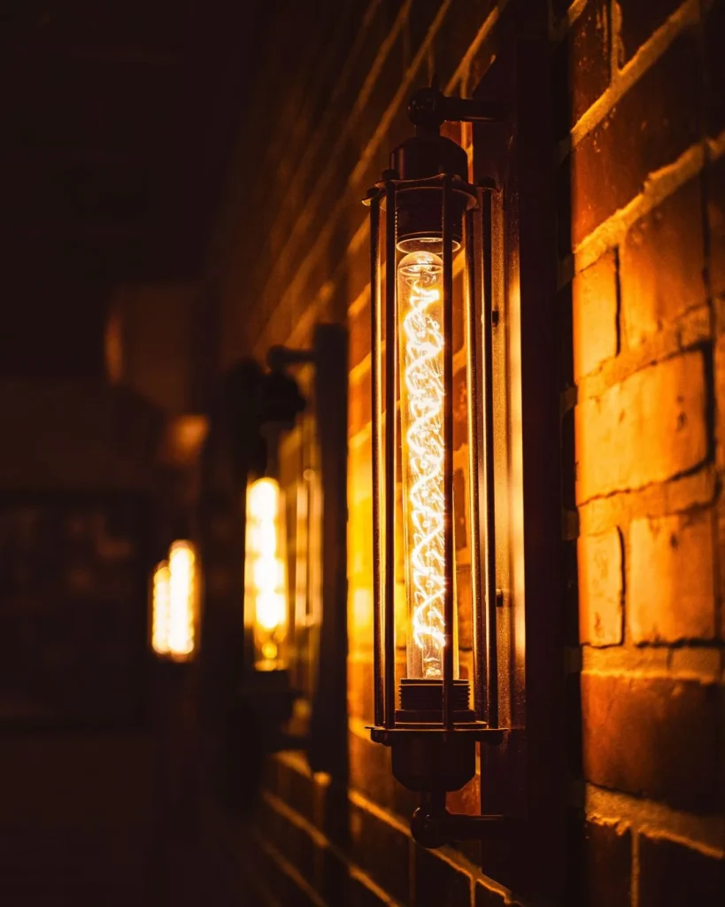 up-and-down wall sconces on a basement hallway wall with exposed brick veneer