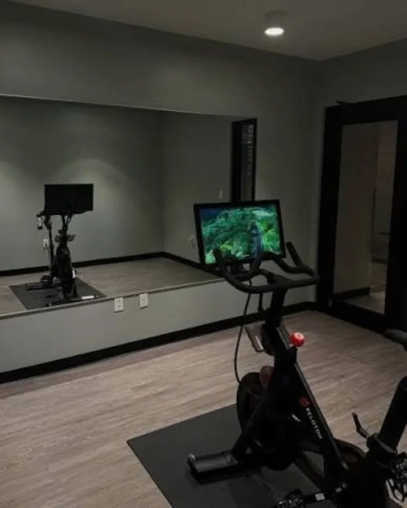 Dark moody home cycling studio with LED strip lighting behind bike