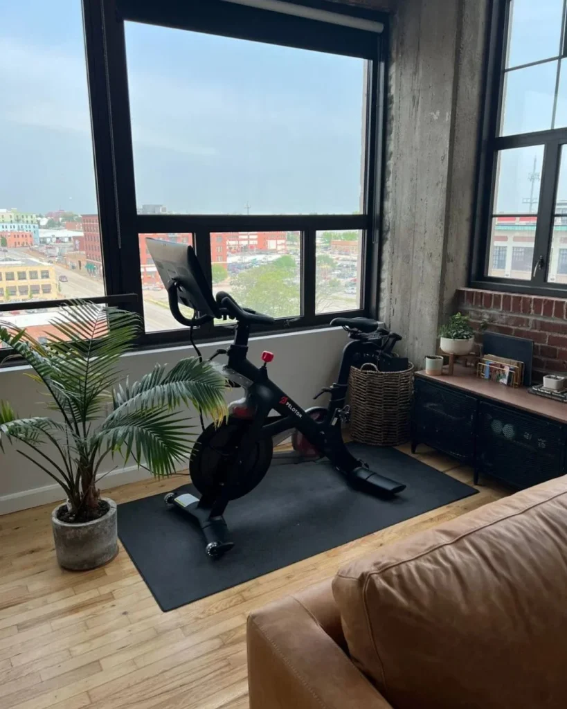 Industrial Peloton room with brick wall, black hooks and metal shelving